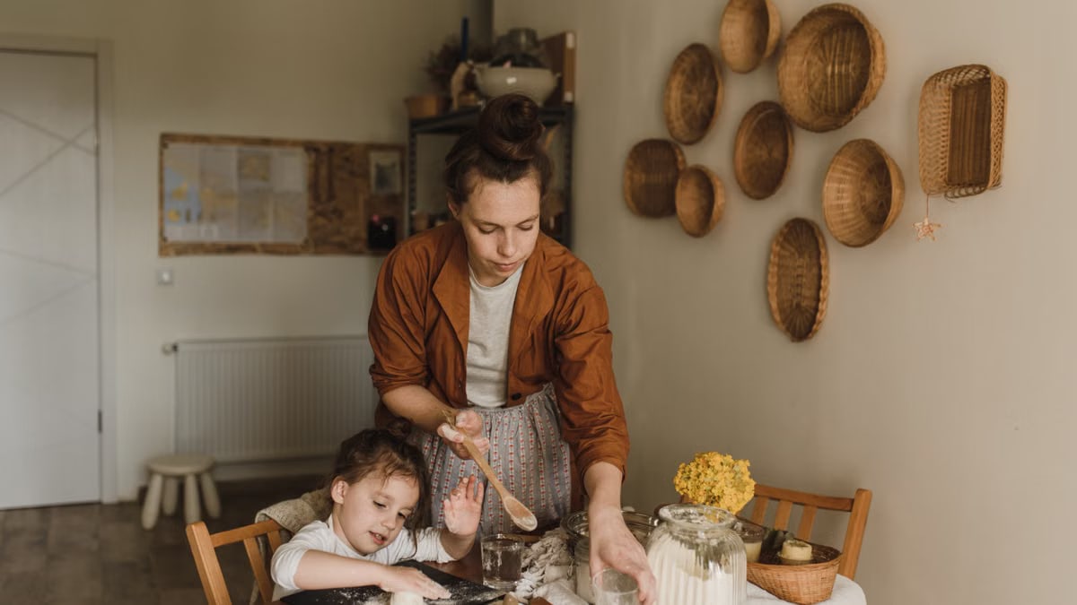 A mother and daughter enjoy baking together in a cozy, rustic kitchen setting.
